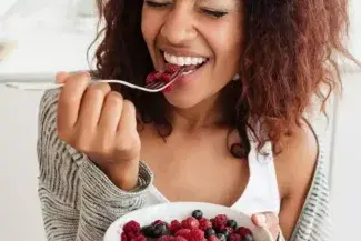 6 passos para comer melhor no dia a dia: mulher comendo frutas vermelhas 